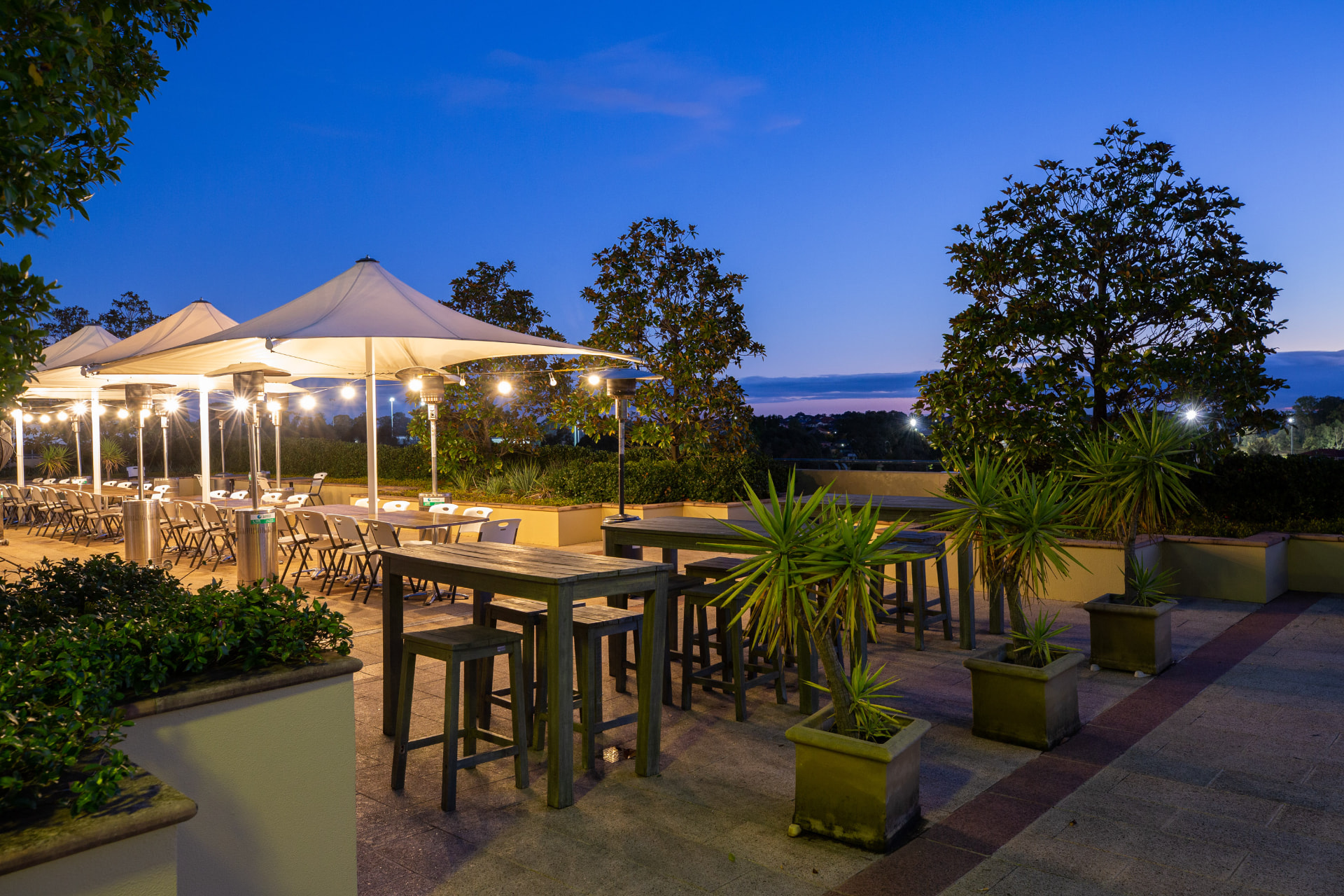 Outdoor bar tables lit at twilight