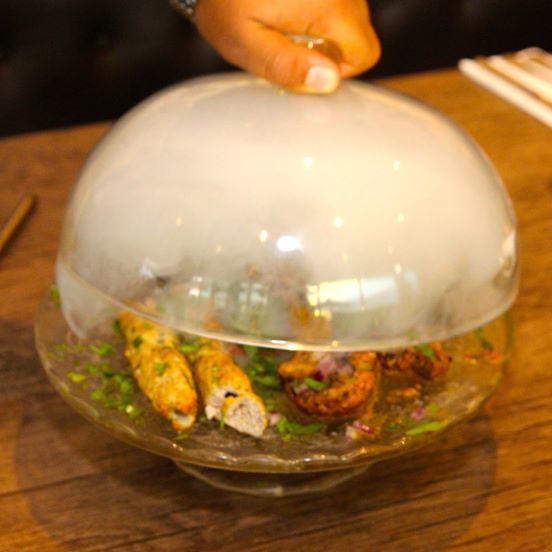 Original photograph of the Smoked Platter served under a smoke-filled glass dome