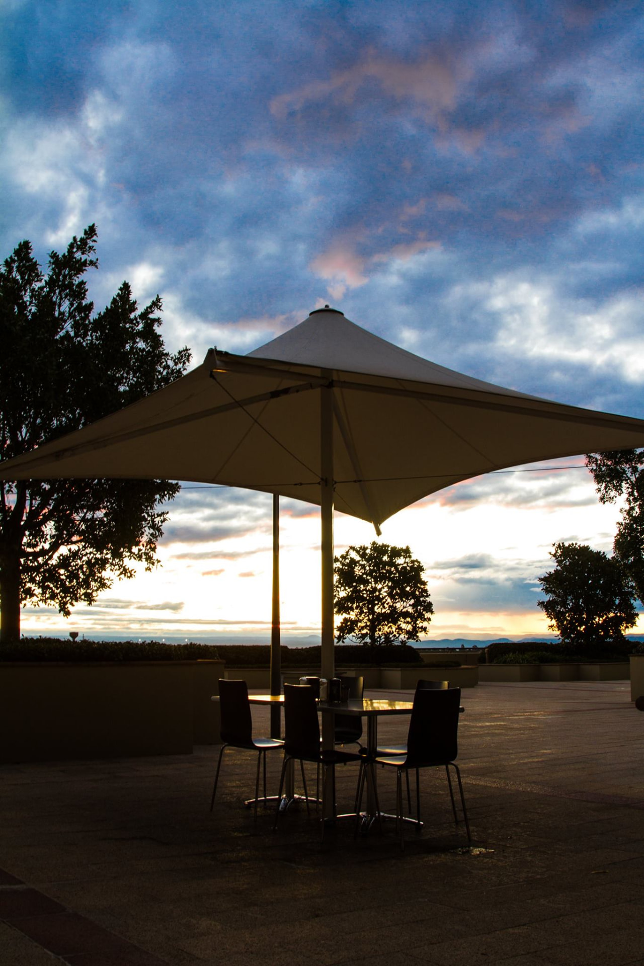 Table and chairs silhouetted against a bright sunset