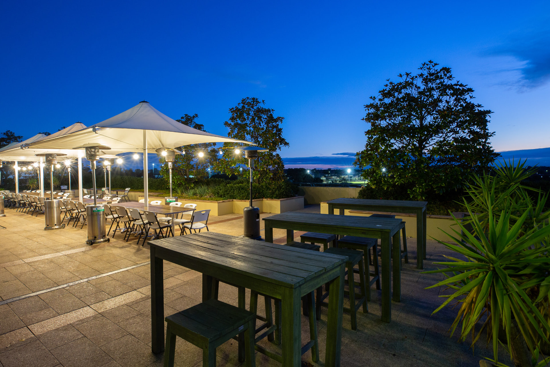 Terrace umbrellas and string lights at dusk