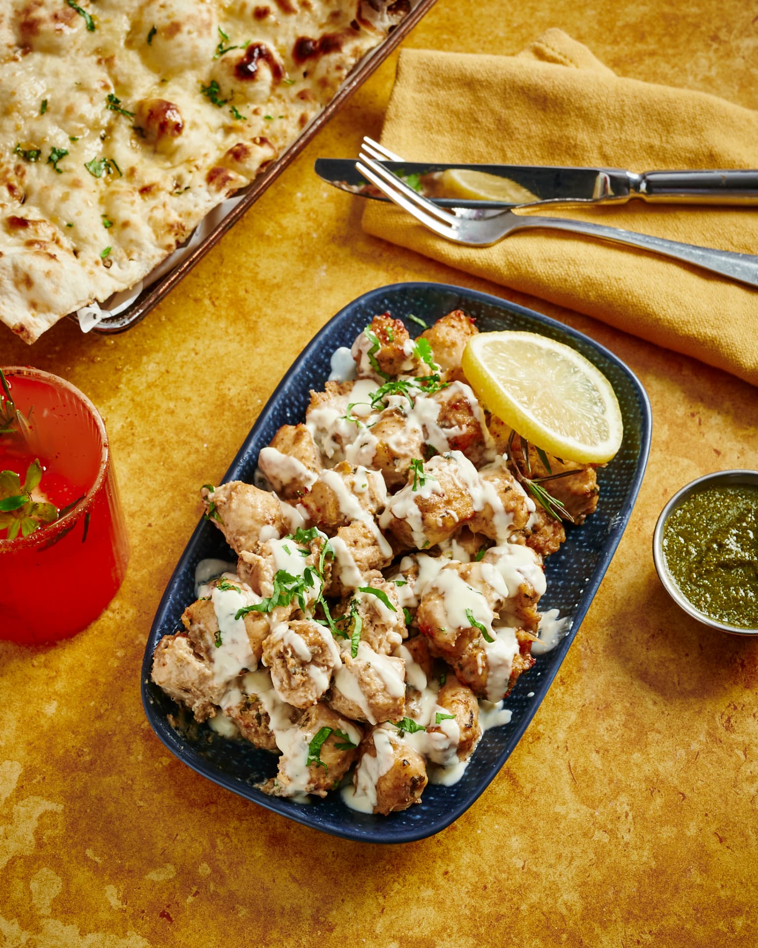 Original photograph of Malai Chap — creamy marinated soy chunks on a navy platter with buttered naan, green chutney and a lemon wheel