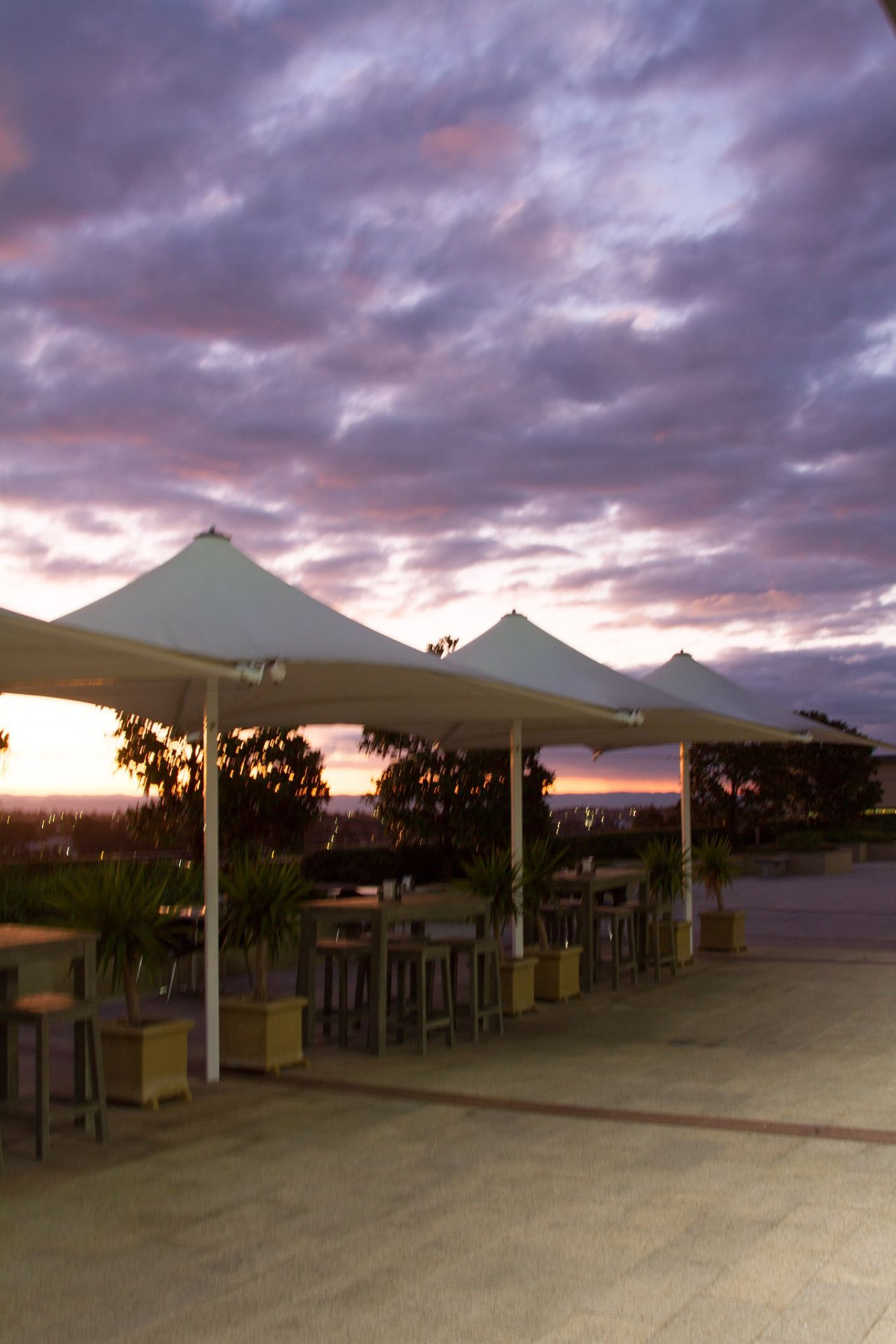 Terrace tables beneath dramatic purple clouds at dusk