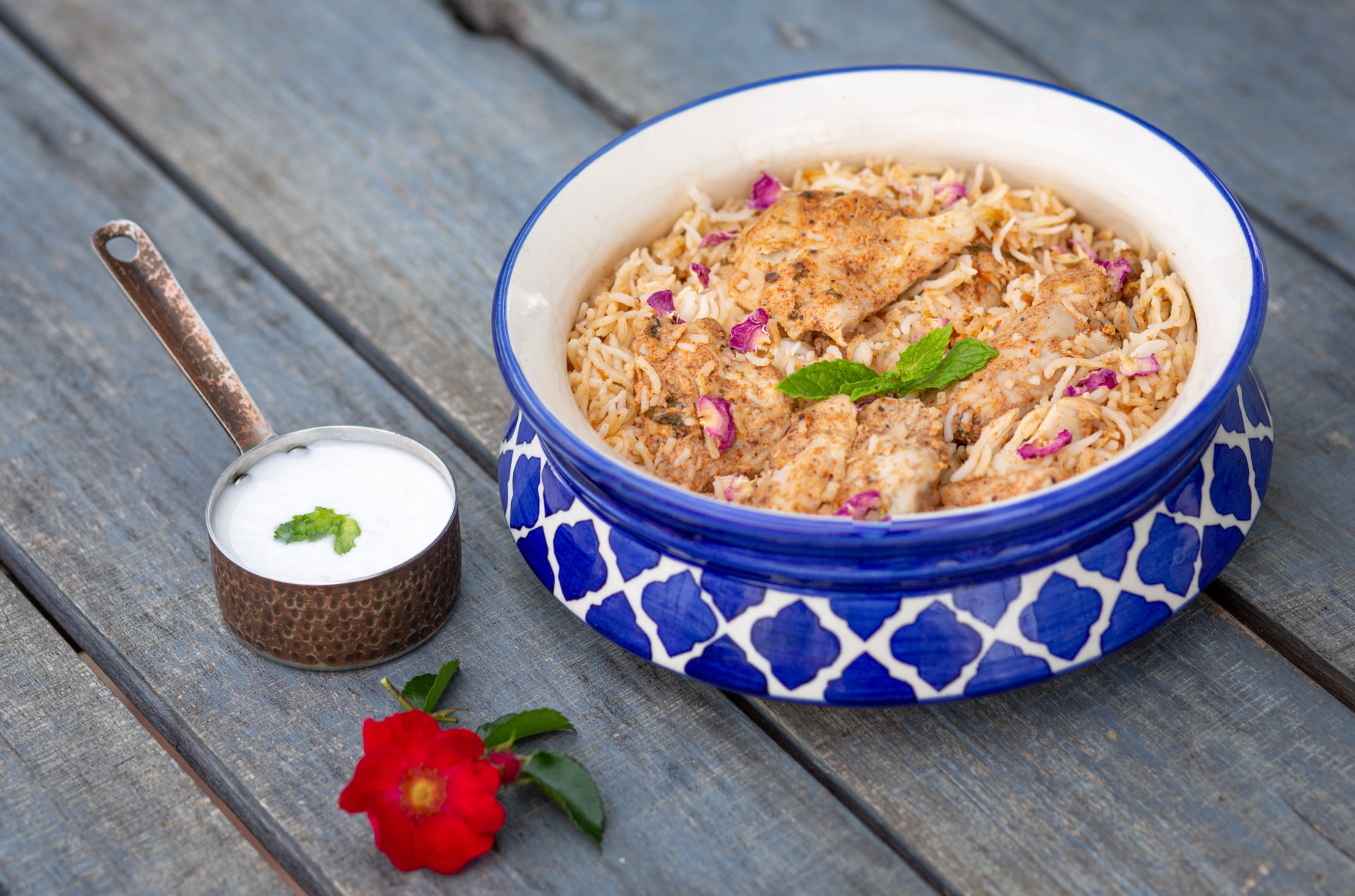 Original photograph of Dum Pukht Awadhi Murg Biryani with rose petals and raita