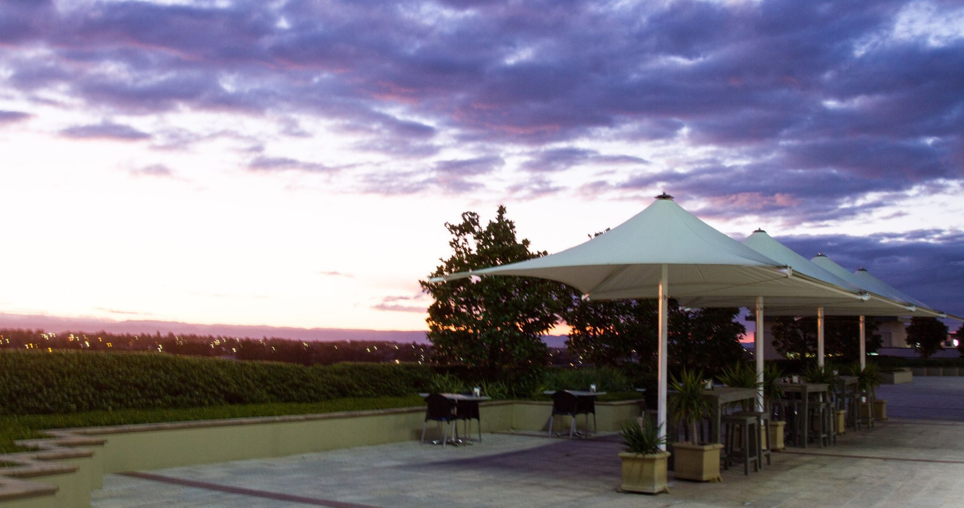 Wide terrace view under a purple and pink sunset sky