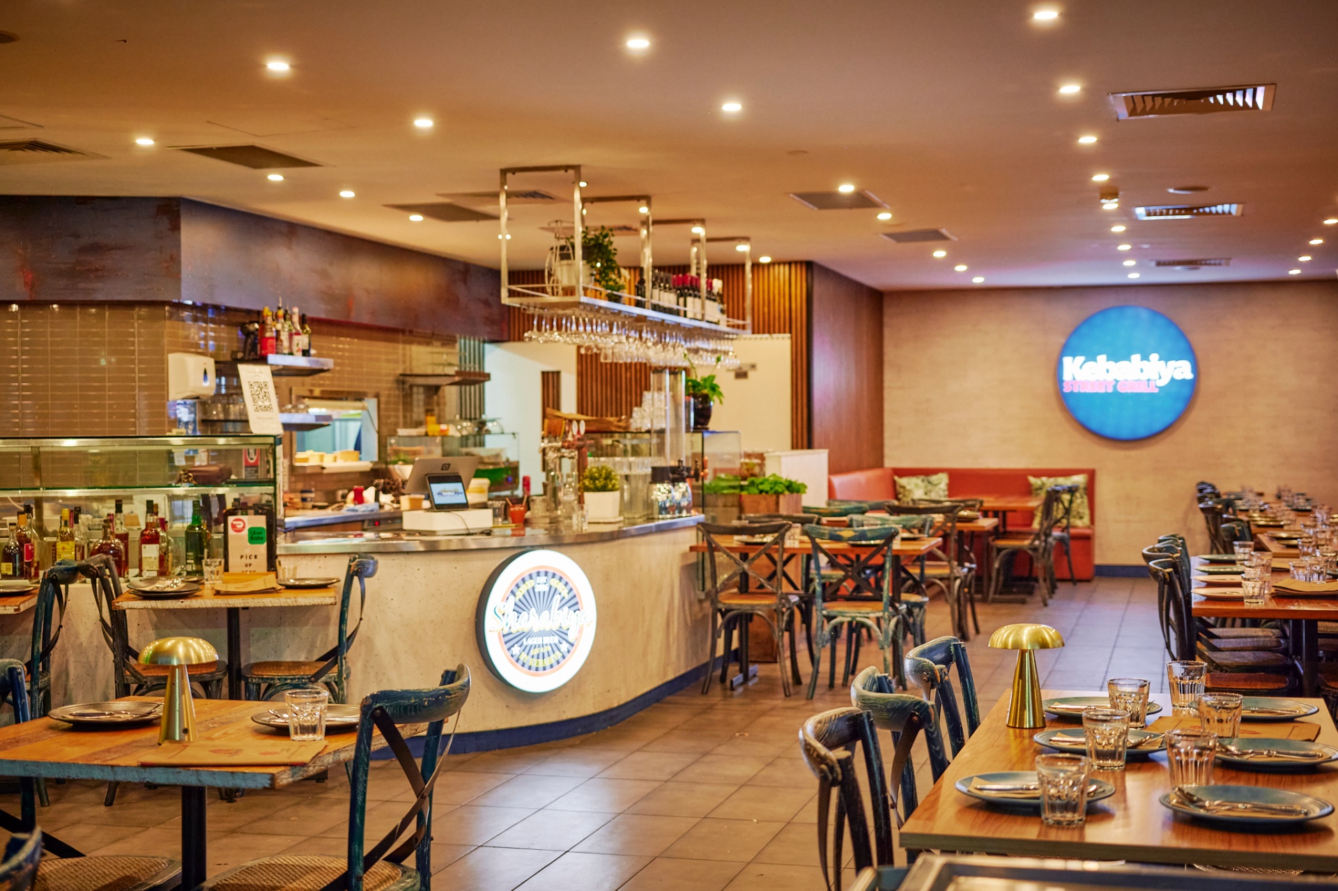 Warm interior of Kebabiya Bella Vista with brass pendant lights