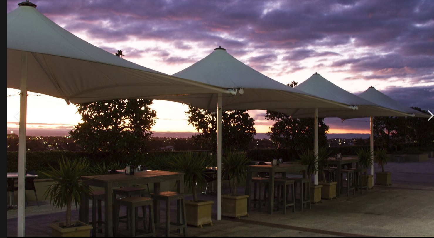 Kebabiya Bella Vista — open-air terrace under sail canopies at sunset, looking west across Sydney